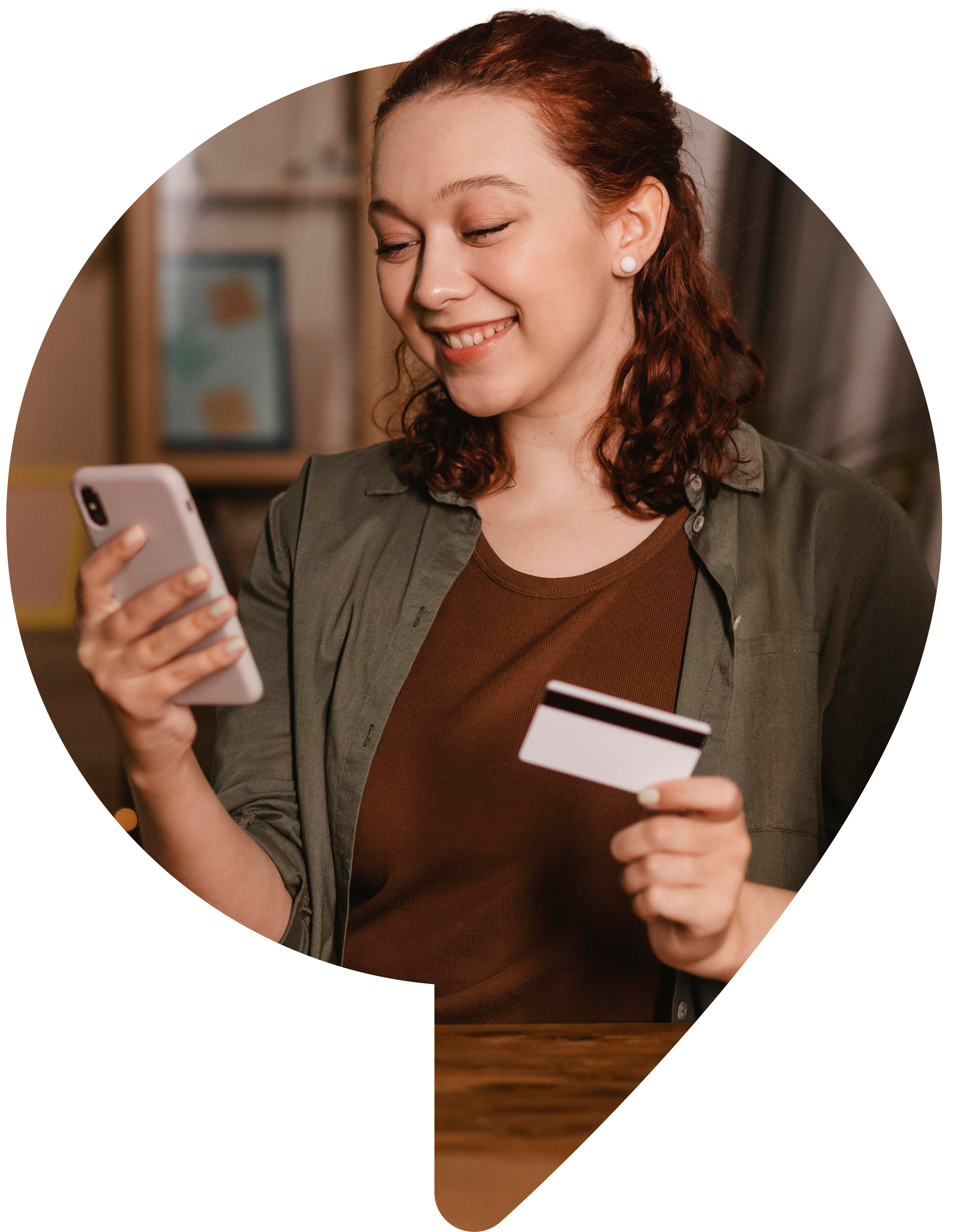 Mujer sonriente usando su smartphone en casa con tarjeta de crédito